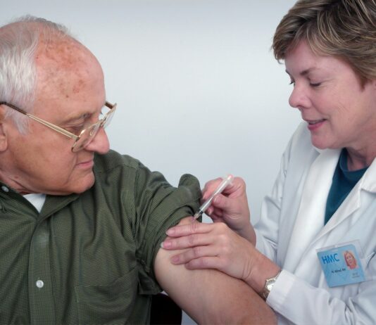 노인 질환 예방을 위한 예방 접종과 건강 검진 woman injecting syringe on mans arm