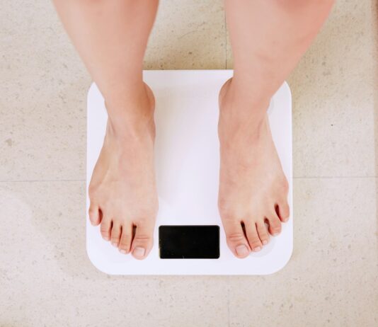 다이어트를 위한 효과적인 방법 person standing on white digital bathroom scale