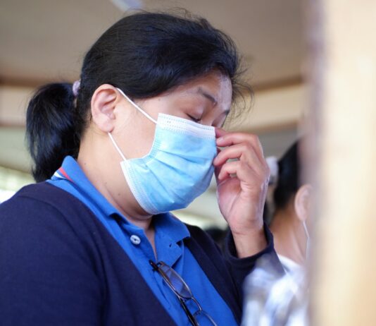 UN, 만성질환 대응 강화 촉구… “NCDs는 조용한 팬데믹” woman in blue shirt covering face with white paper