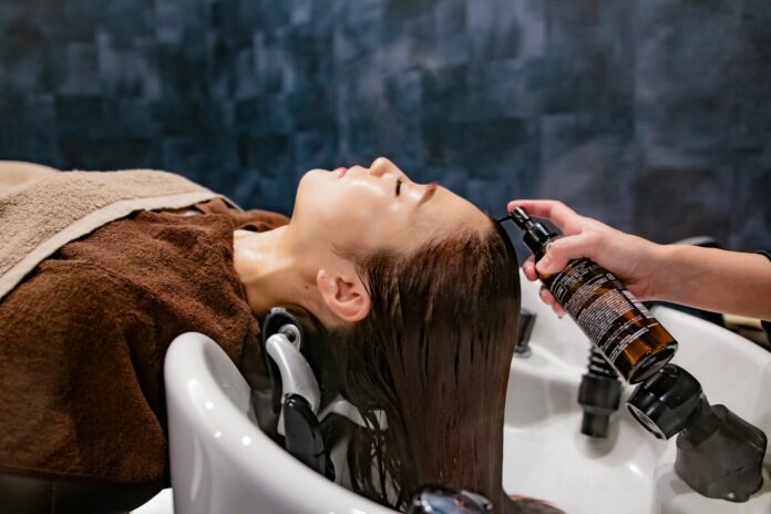 Photo by QUENTIN Mahe a woman getting her hair washed in a sink