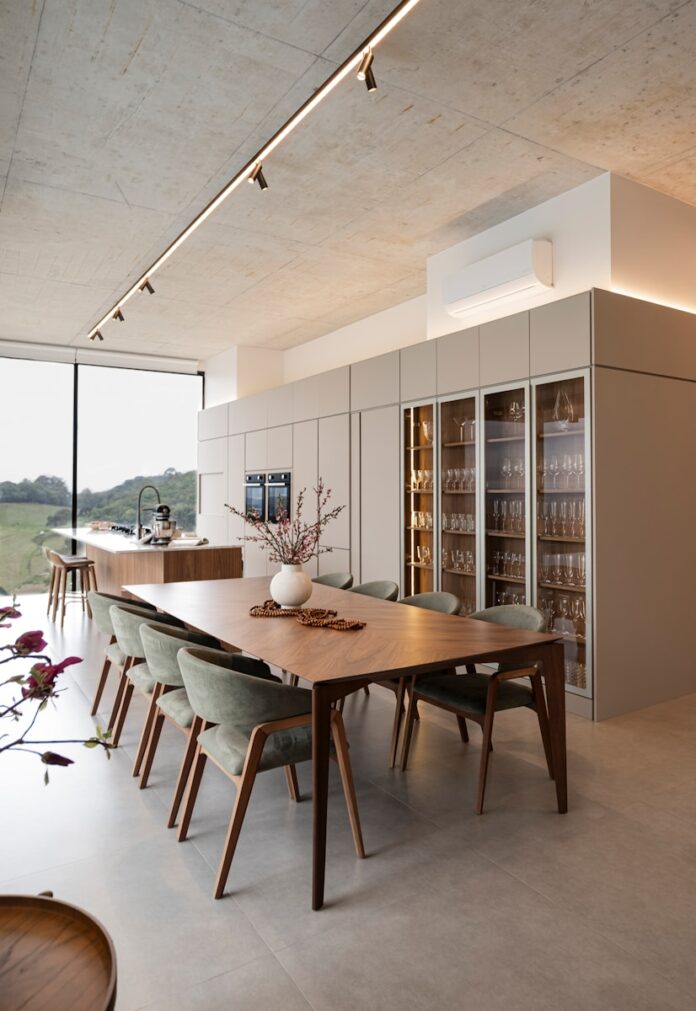 Photo by Caroline Badran Modern dining room with large table and wine cabinet.