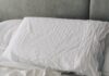 수면의 질을 높이는 생활 습관, 실천 가능한 작은 변화에서 시작 A rumpled white duvet and pillows on a bed.