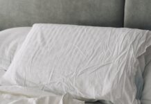 수면의 질을 높이는 생활 습관, 실천 가능한 작은 변화에서 시작 A rumpled white duvet and pillows on a bed.