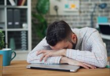 만성피로, 일상 변화로 극복한다… ‘느린 아침’과 ‘마음챙김’ 루틴 주목 a man sitting at a desk with his head in his hands